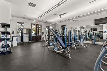 A gym with a variety of equipment including weights and machines. at Bridge at Indigo, Texas